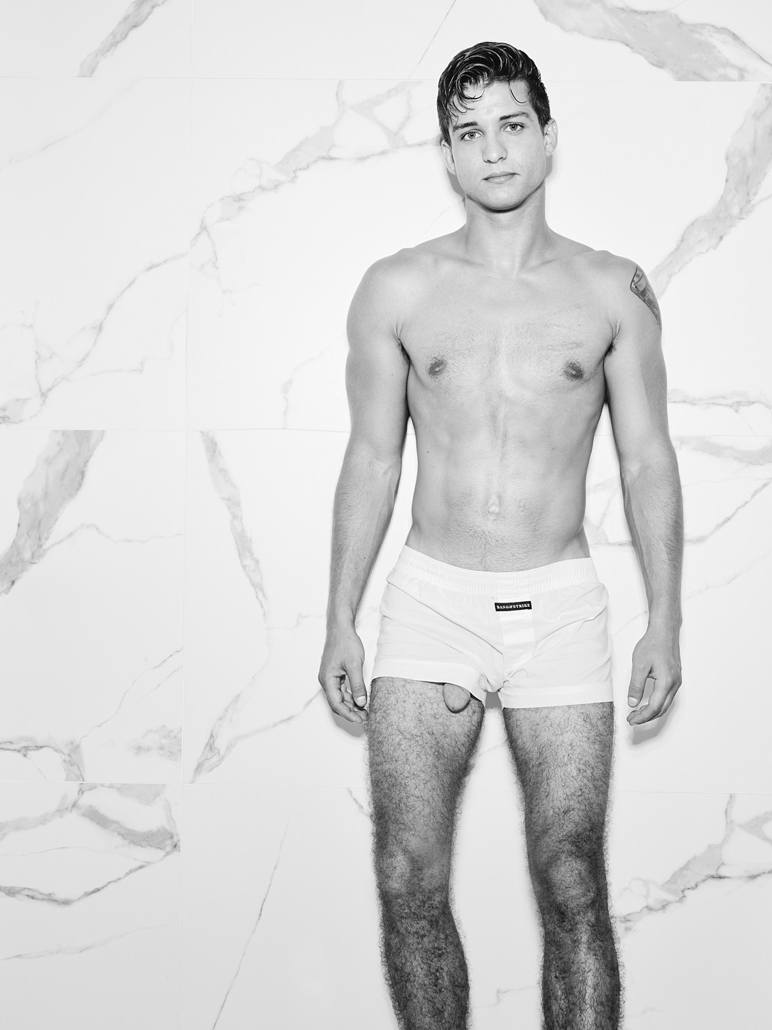 hung model Elliot Finn showing the head of his penis from the bottom of the leg of his boxer shorts